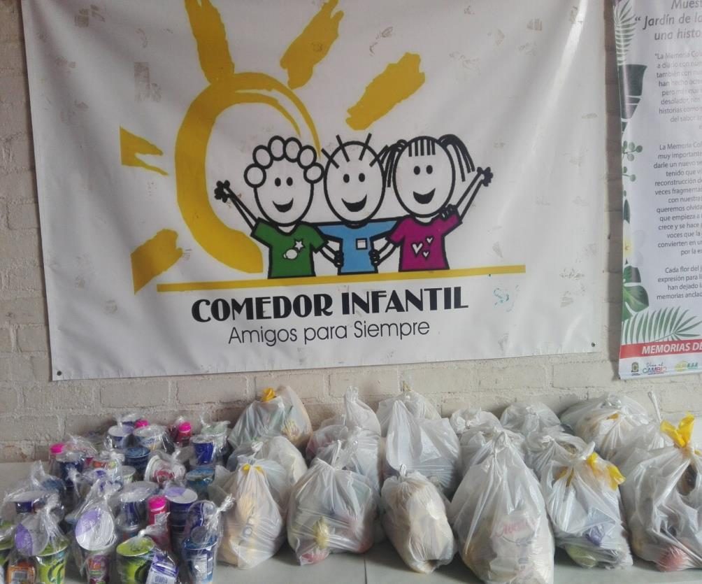 Bolsas de alimentos frente al logo del comedor infantil