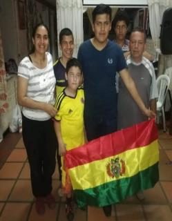 Familia migrante sosteniendo una bandera
